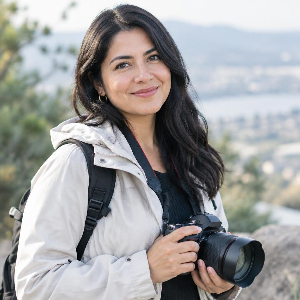 Portrait of a young woman photographer outdoors