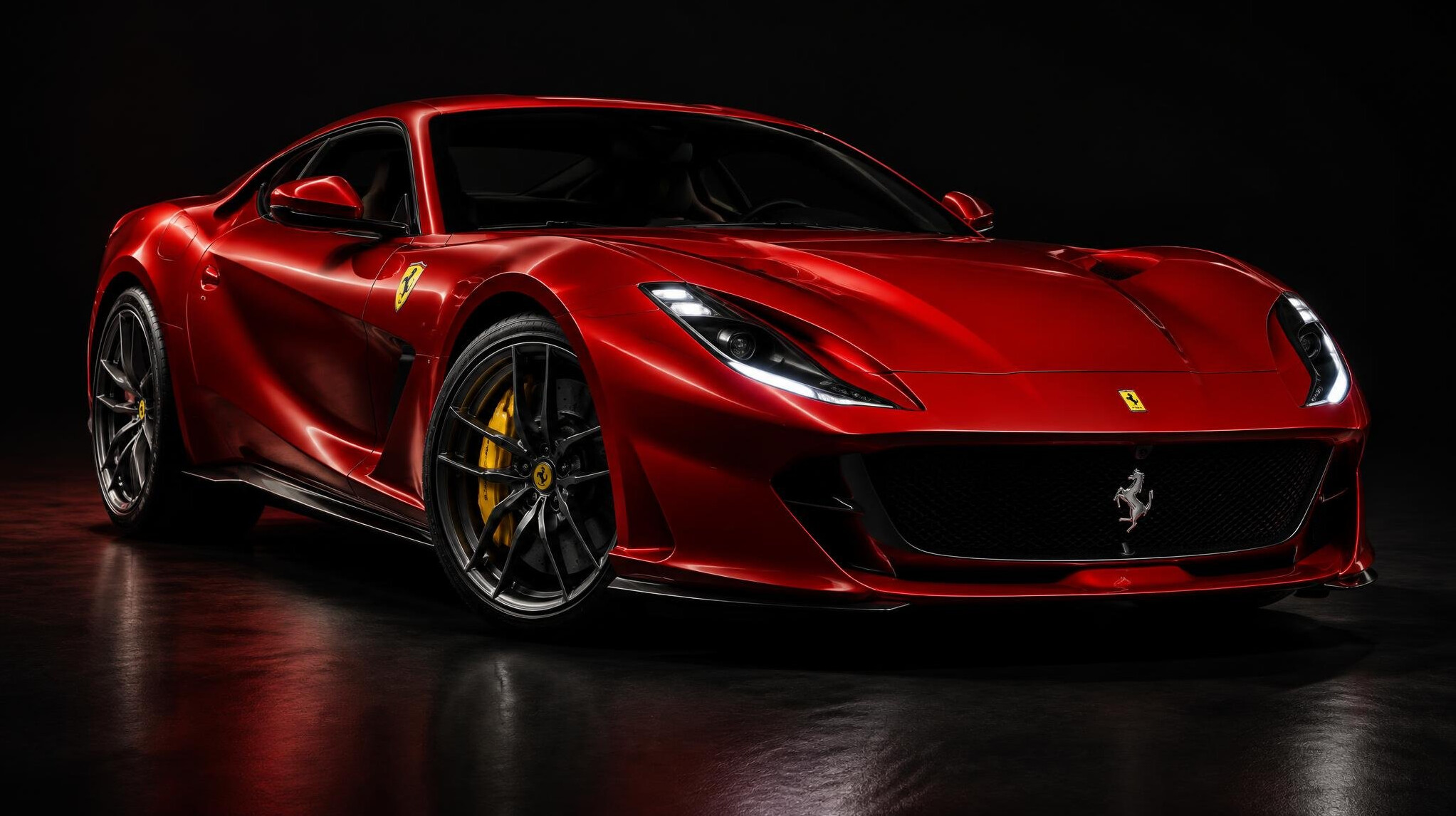 Red Italian sports car parked in a studio-like setting